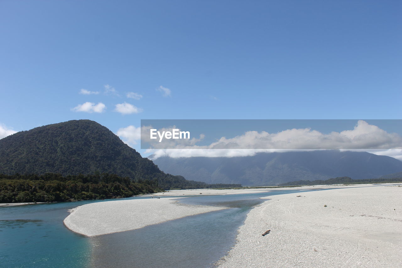 Scenic view of beach against blue sky