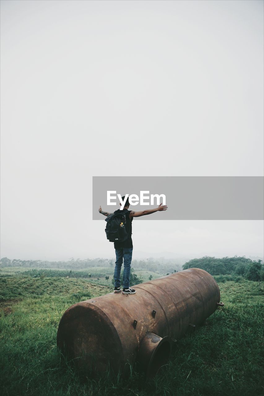 FULL LENGTH OF MAN STANDING ON FIELD AGAINST SKY