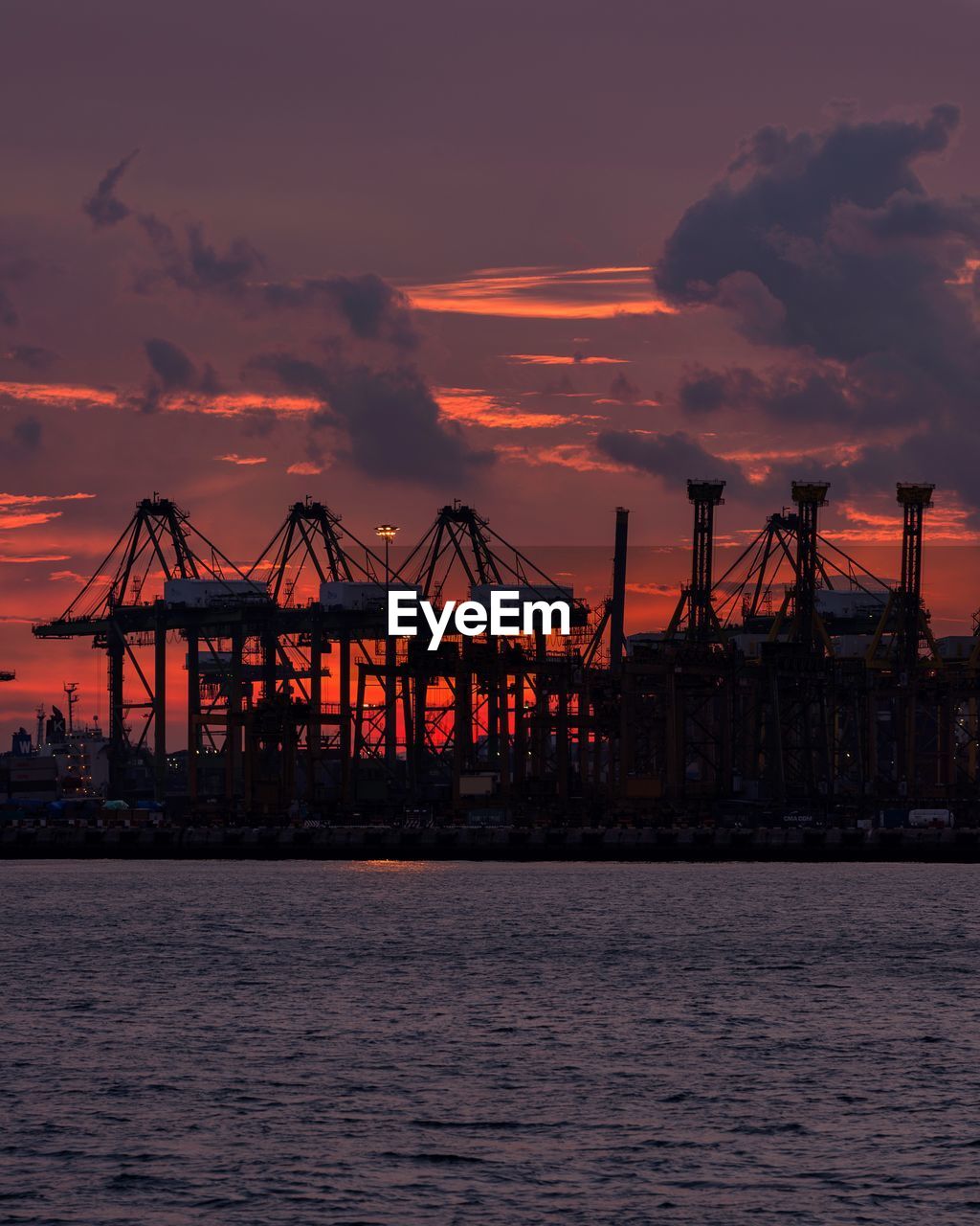 SILHOUETTE CRANES AGAINST SKY DURING SUNSET