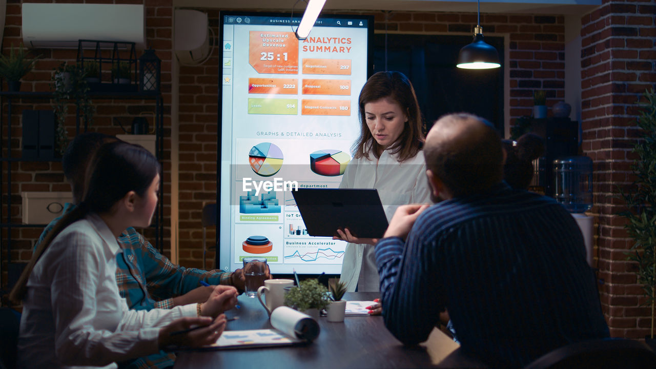 side view of woman using mobile phone while standing in office