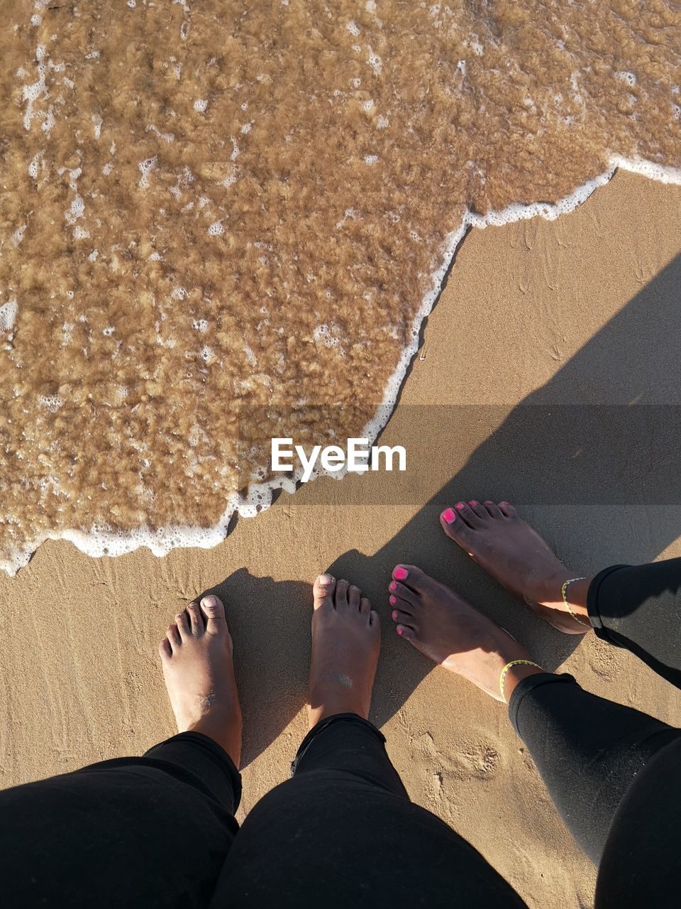 Low section of people standing on beach