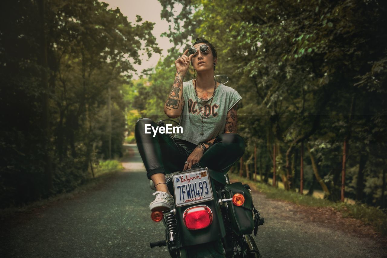 FULL LENGTH PORTRAIT OF WOMAN RIDING MOTORCYCLE