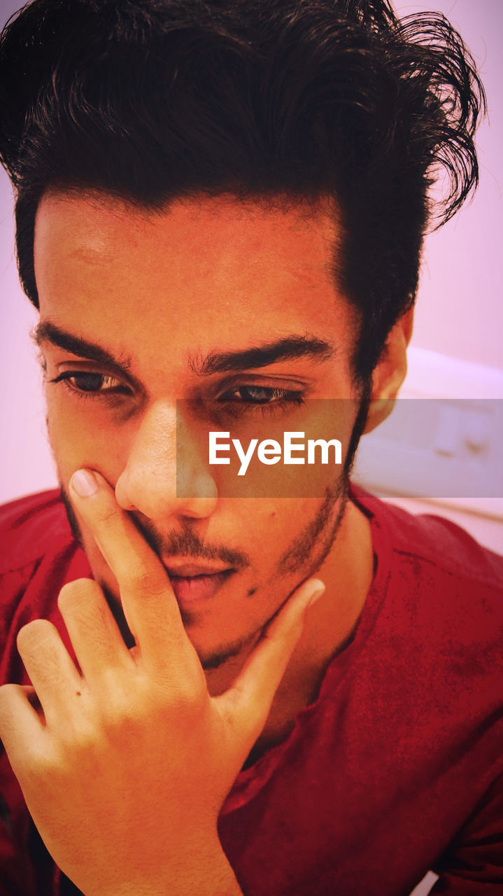 Close-up of thoughtful young man at home