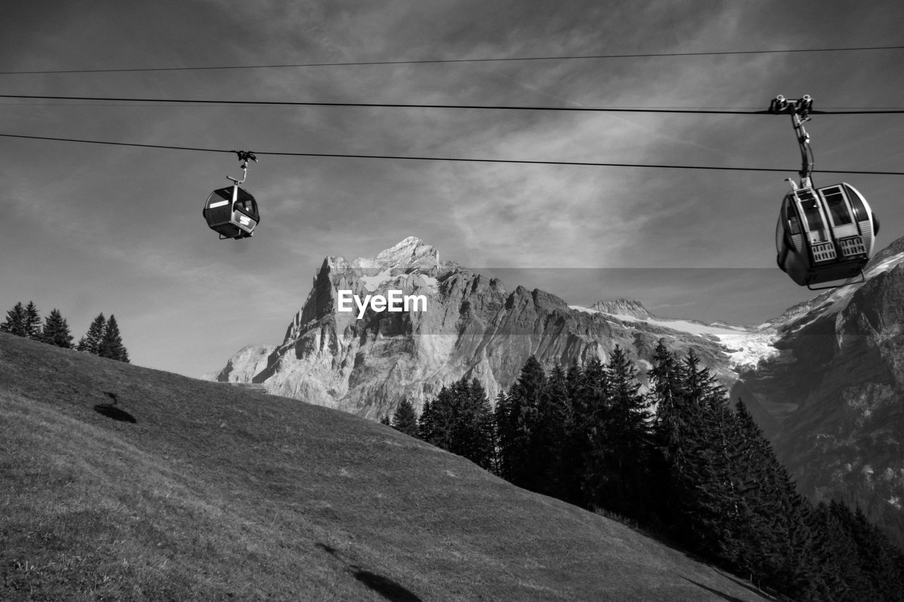 Low angle view of overhead cable car against sky