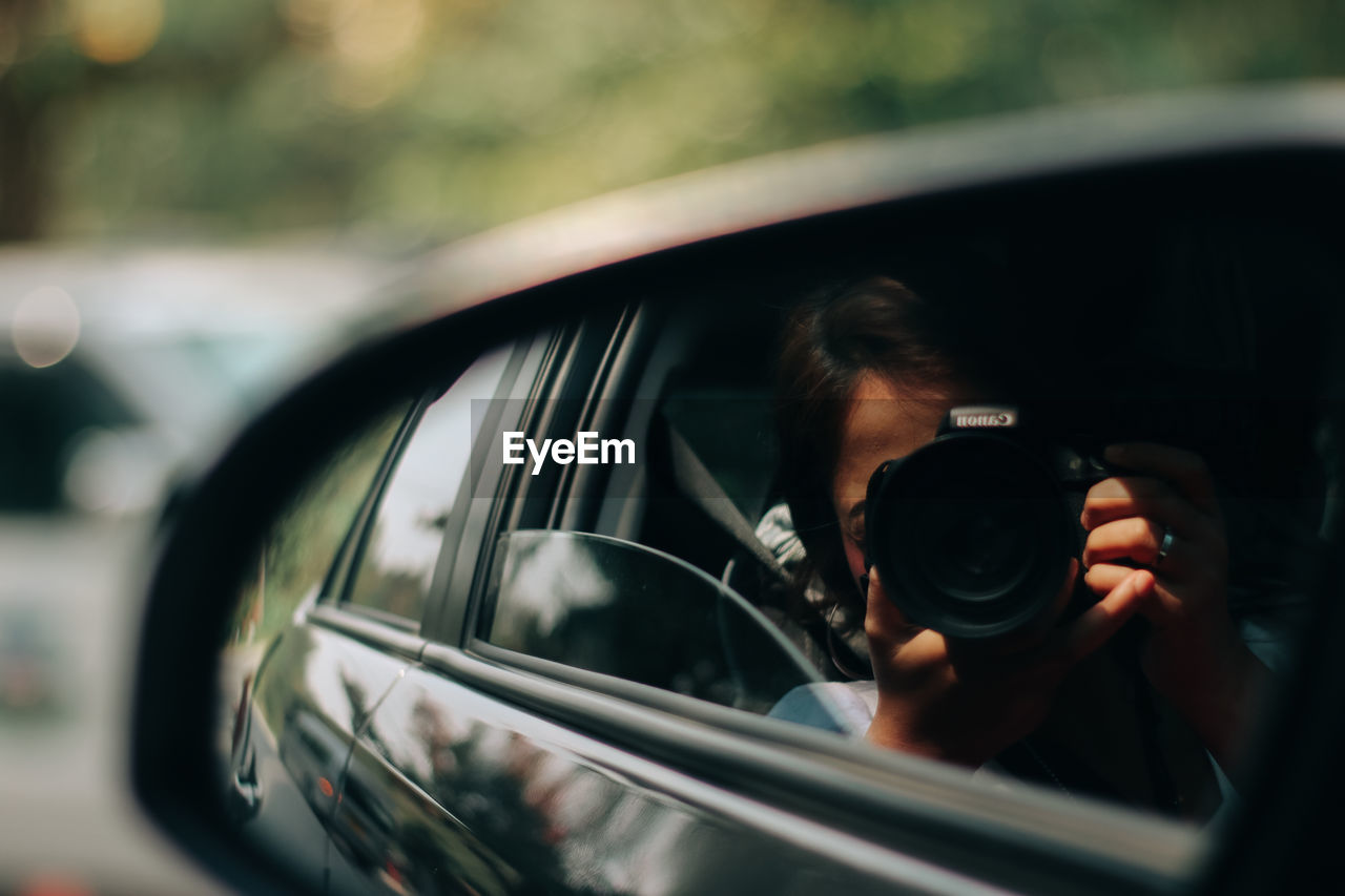 MAN PHOTOGRAPHING THROUGH CAR