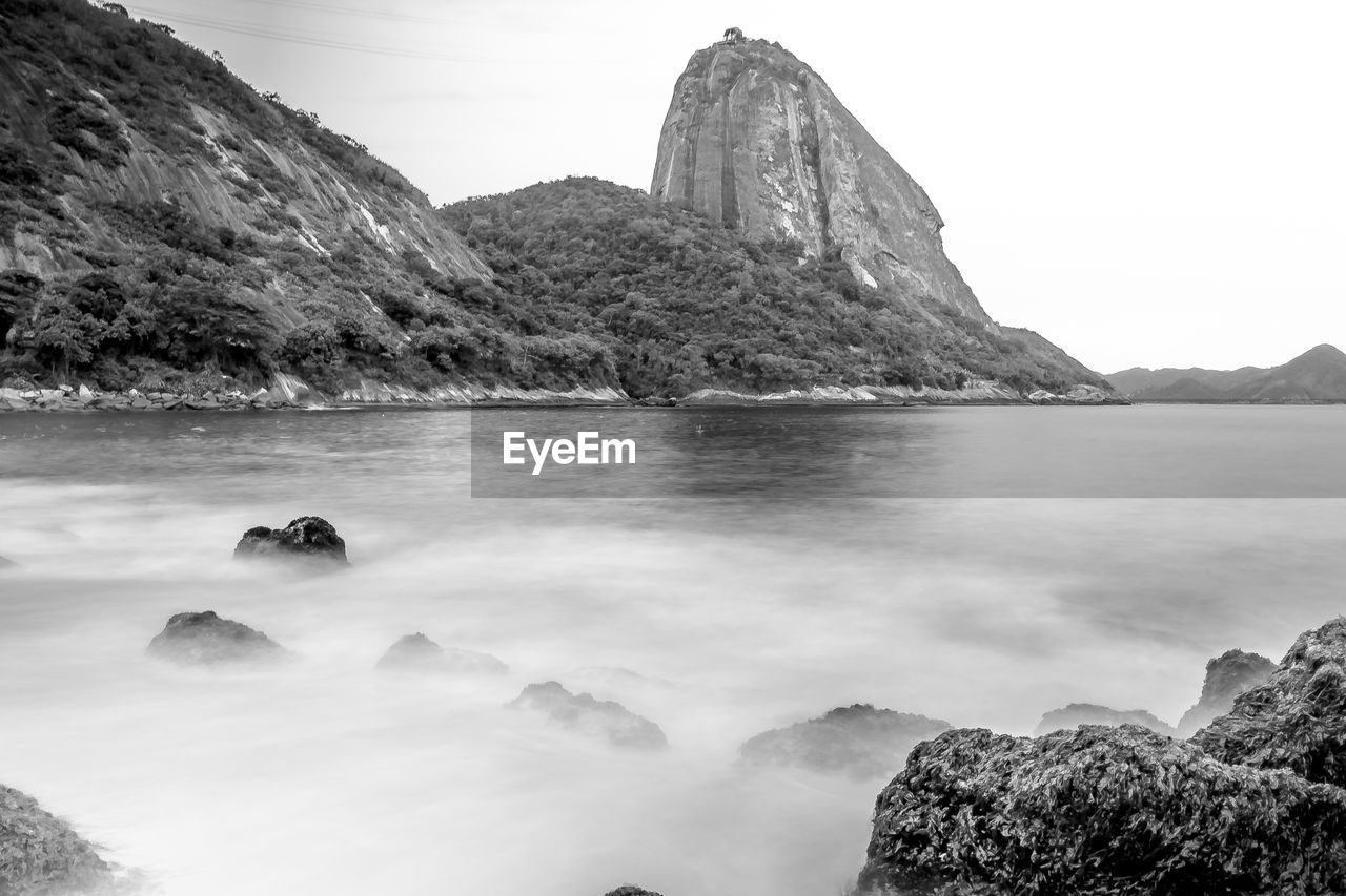 Scenic view of sea and mountains against clear sky