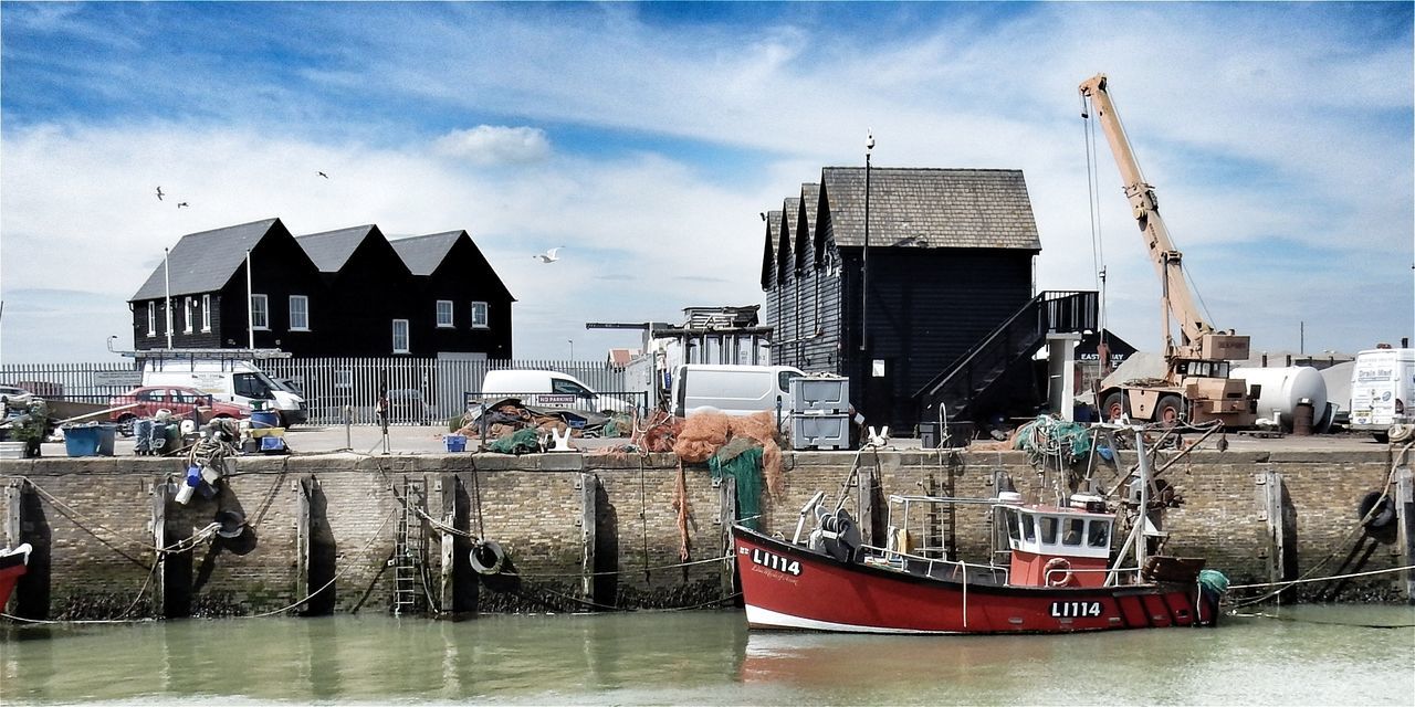 BOATS MOORED AT SEA AGAINST SKY