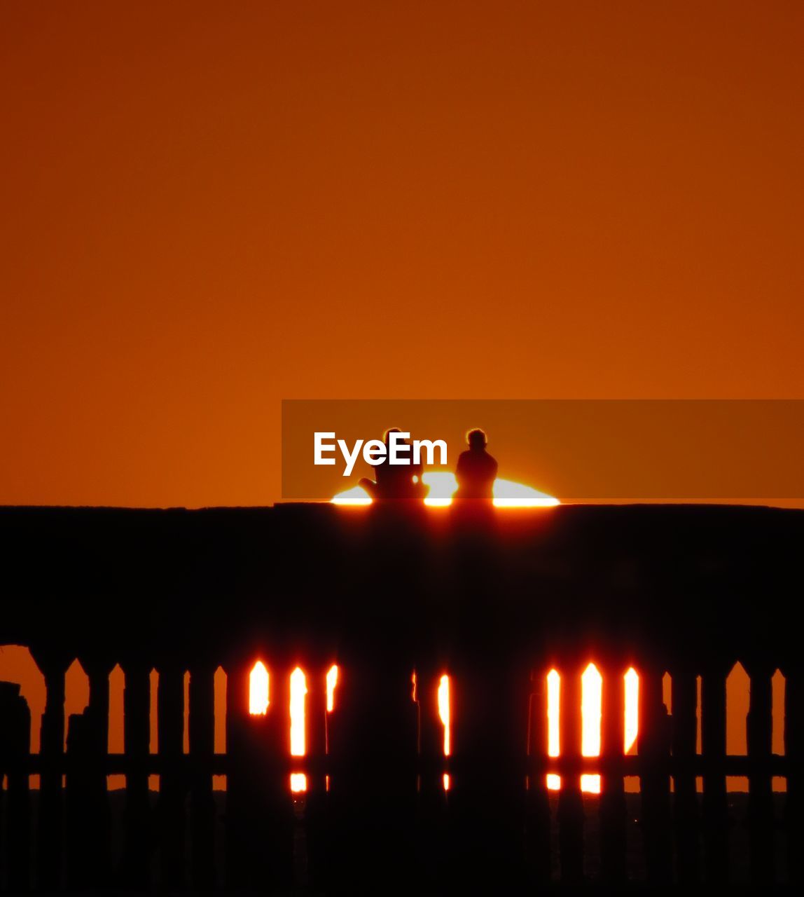 SILHOUETTE PEOPLE AGAINST ILLUMINATED ORANGE SUNSET SKY