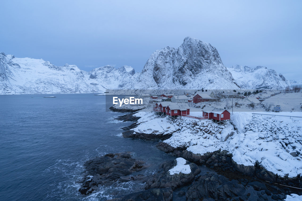 Scenic view of snowcapped mountains by sea against sky