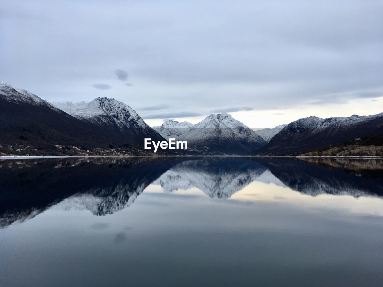 Scenic view of lake and snowcapped mountains against sky