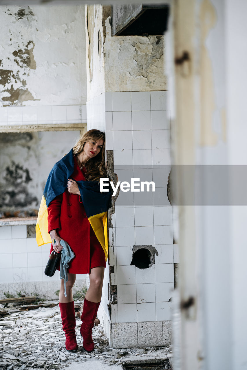 side view of young woman standing in abandoned building