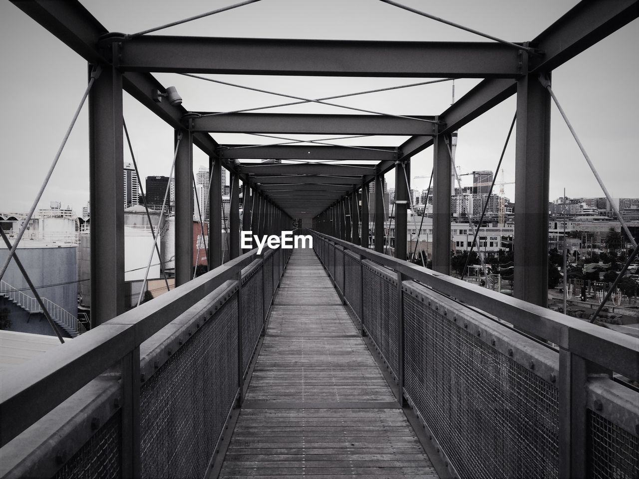 Footbridge against sky in city