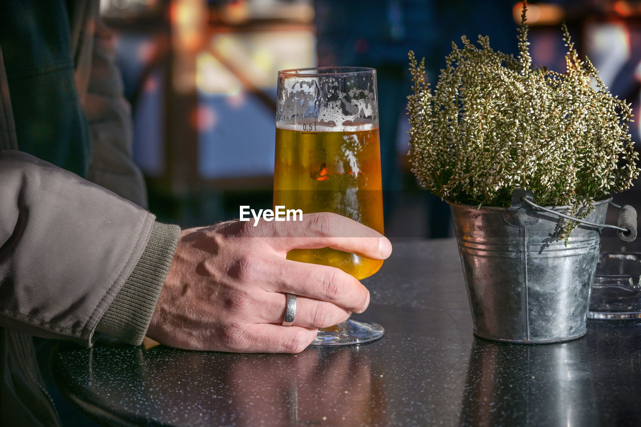 cropped hand of man holding drink