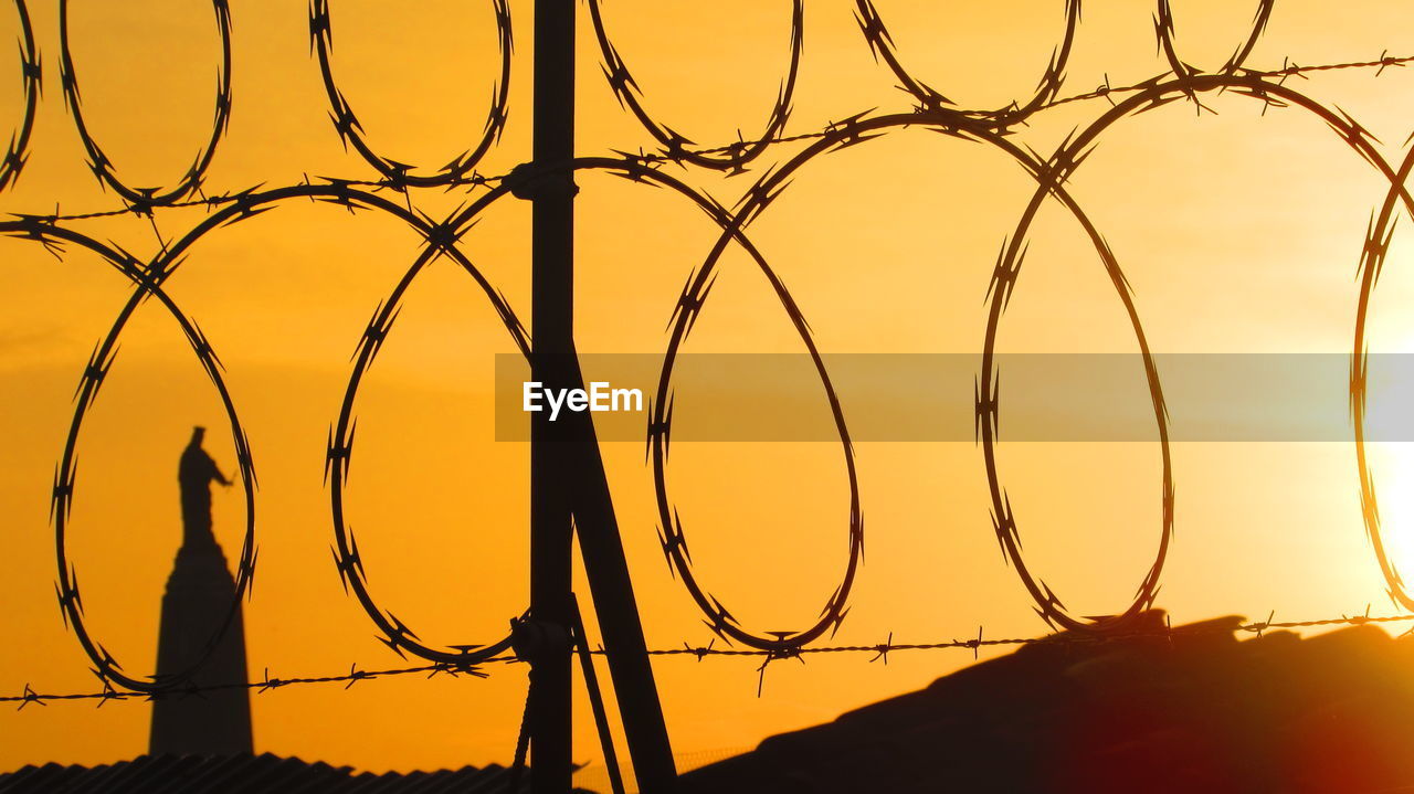 Close-up of spiral razor wire fence at sunset