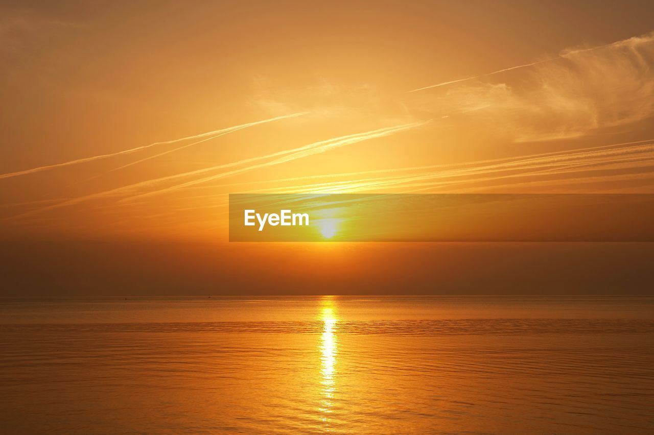 Scenic view of sea against romantic sky at sunset