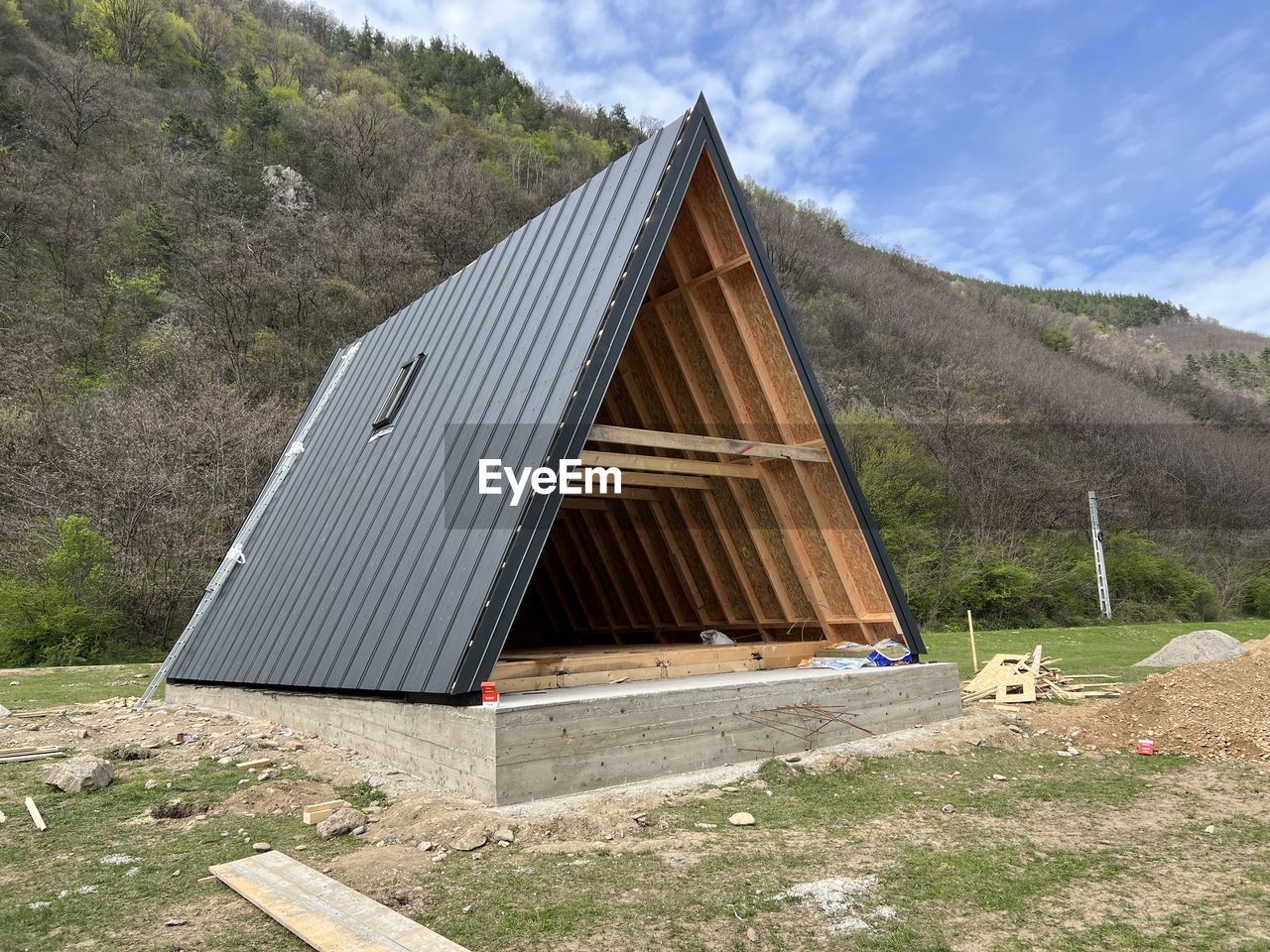 architecture, built structure, sky, hut, nature, environment, building exterior, wood, landscape, roof, mountain, land, plant, solar energy, cloud, no people, day, solar panel, building, shed, environmental conservation, house, outdoors, barn, tree, industry, scenics - nature, grass, non-urban scene, rural area