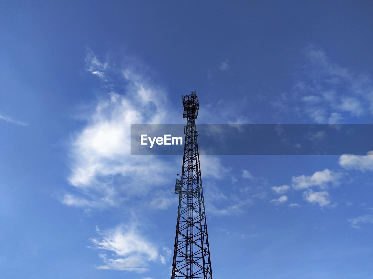 Low angle view of communications tower against blue sky