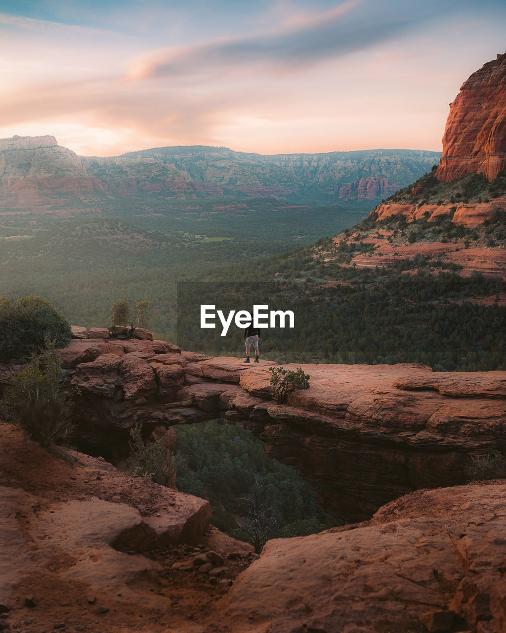 Man standing on cliff against sky