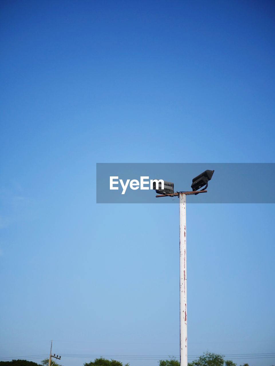 LOW ANGLE VIEW OF FLOODLIGHT AGAINST BLUE SKY