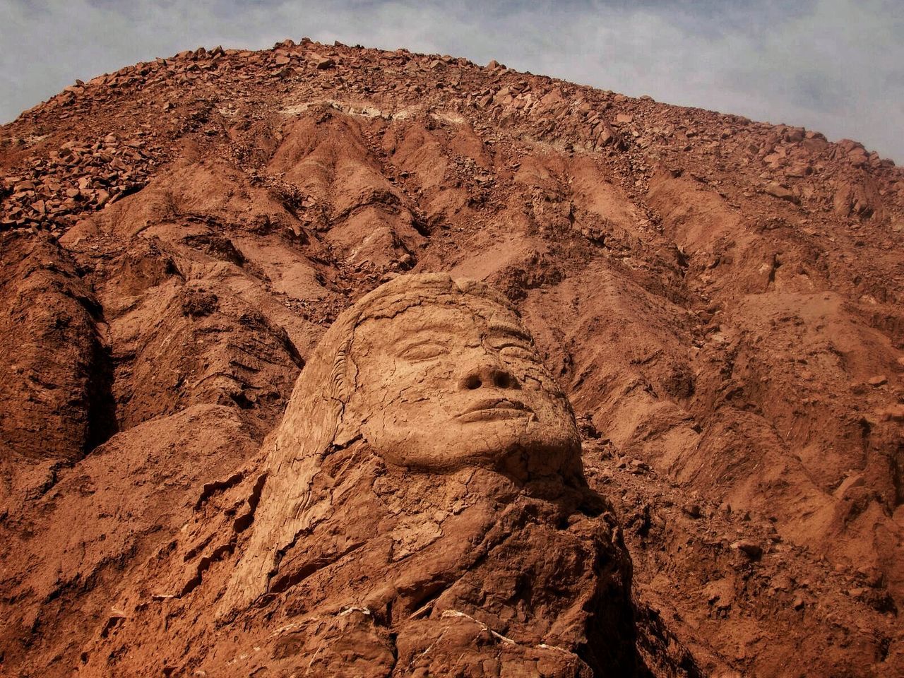 Sculpture of face against sky