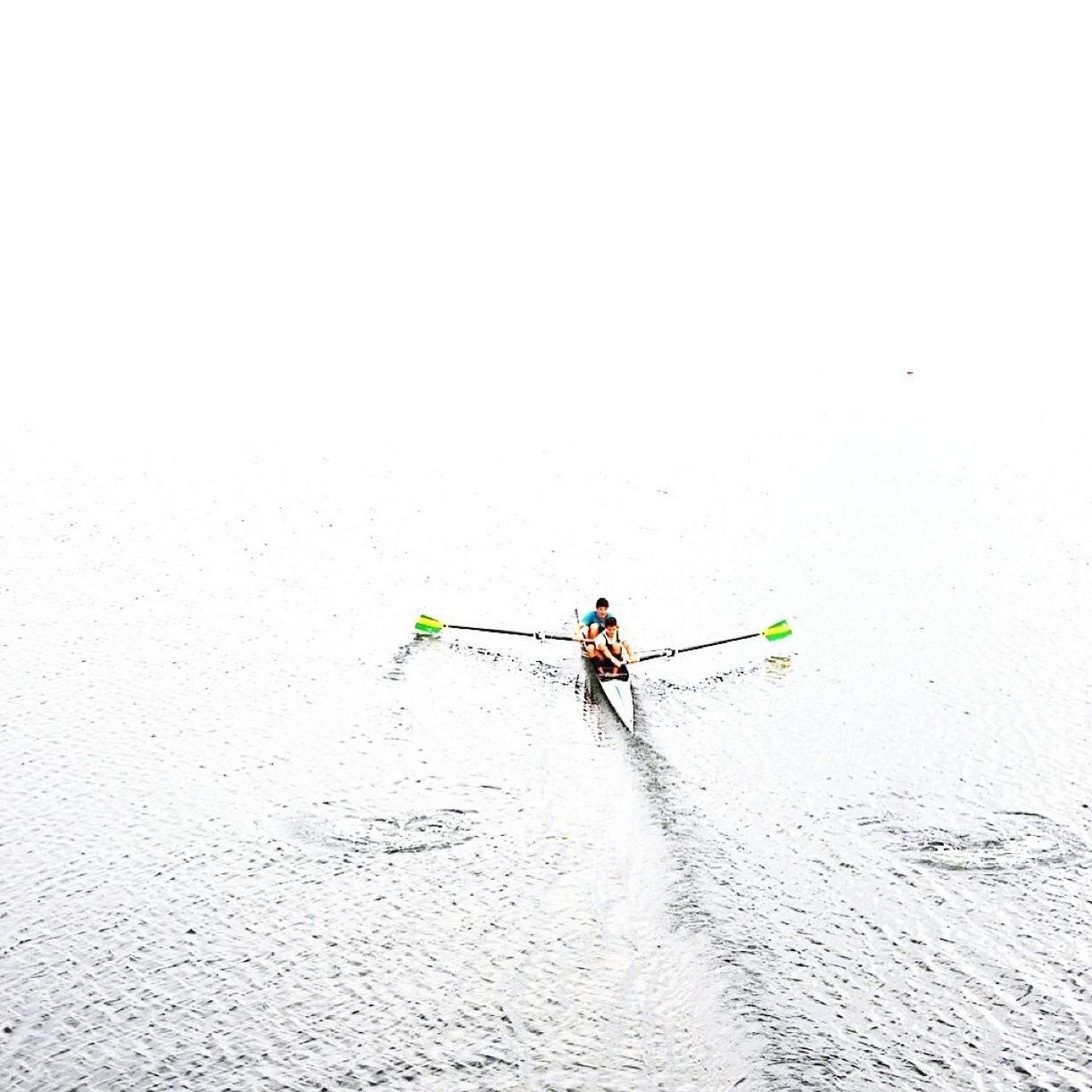 People kayaking on sea against clear sky