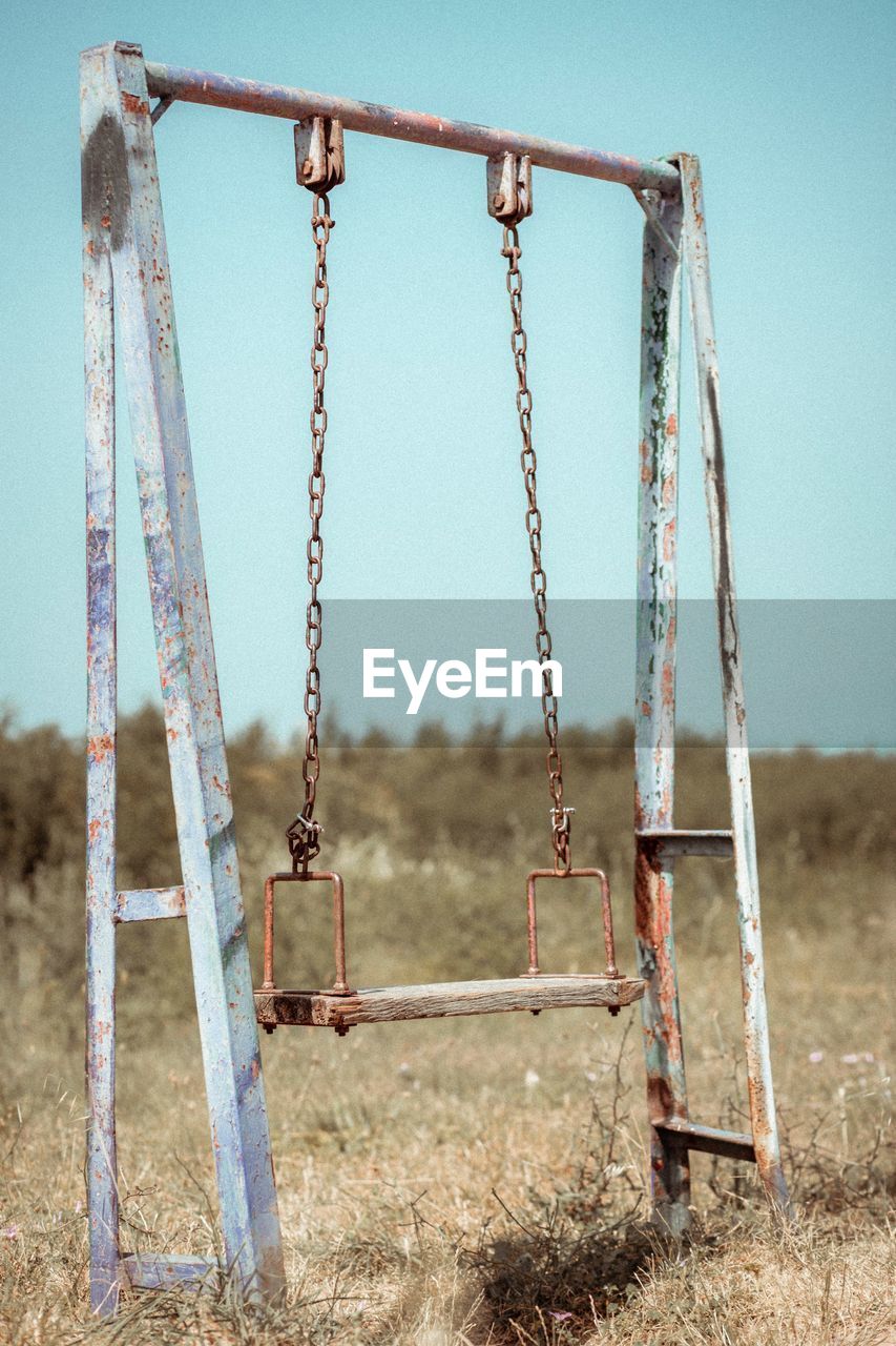 Abandoned swing against clear sky