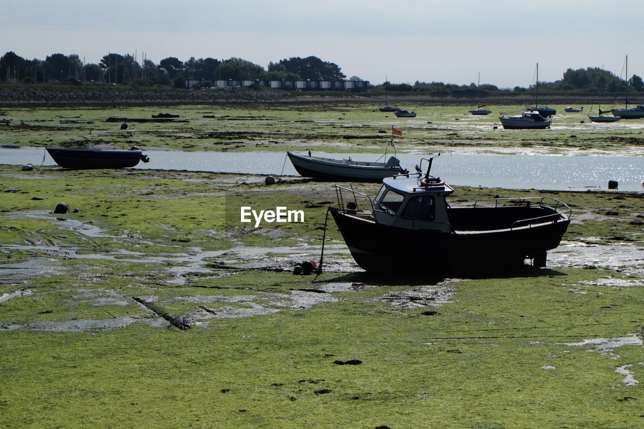 Boats moored on field