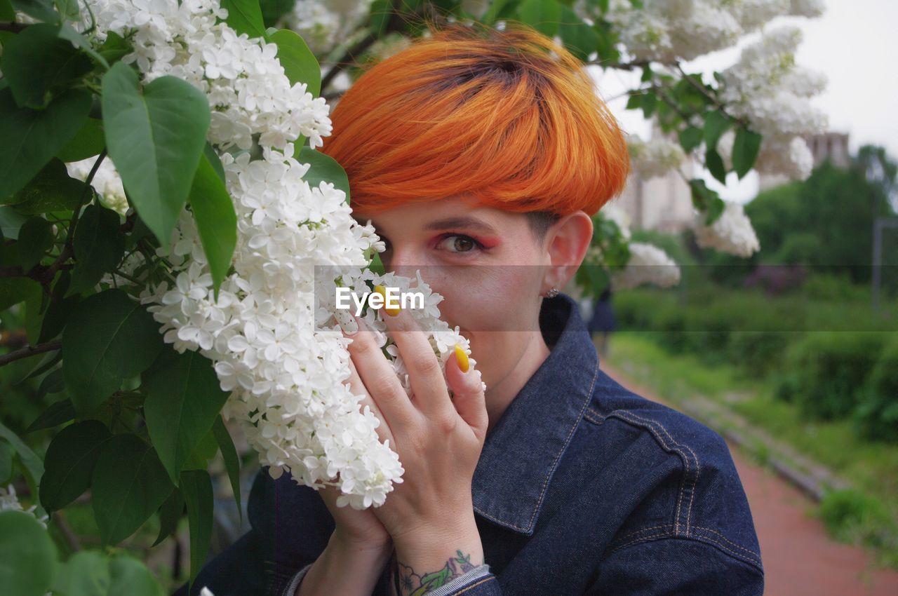 Portrait of woman holding flowering plant