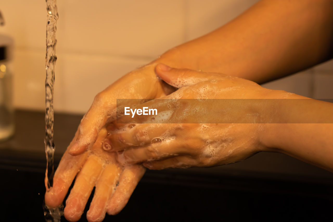 CLOSE-UP OF WOMAN HAND ON WET TABLE DURING BATHROOM