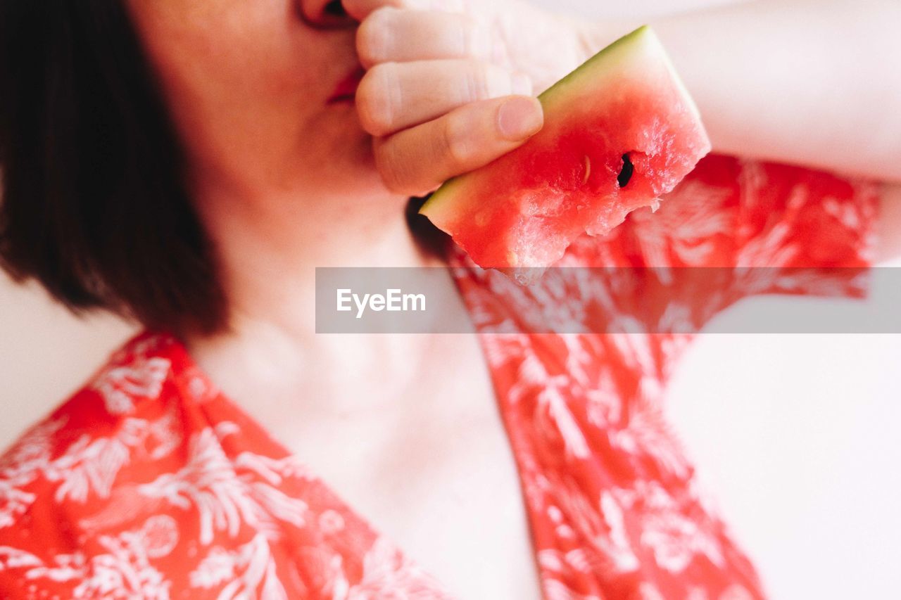 Close-up of woman hand holding red watermelon 