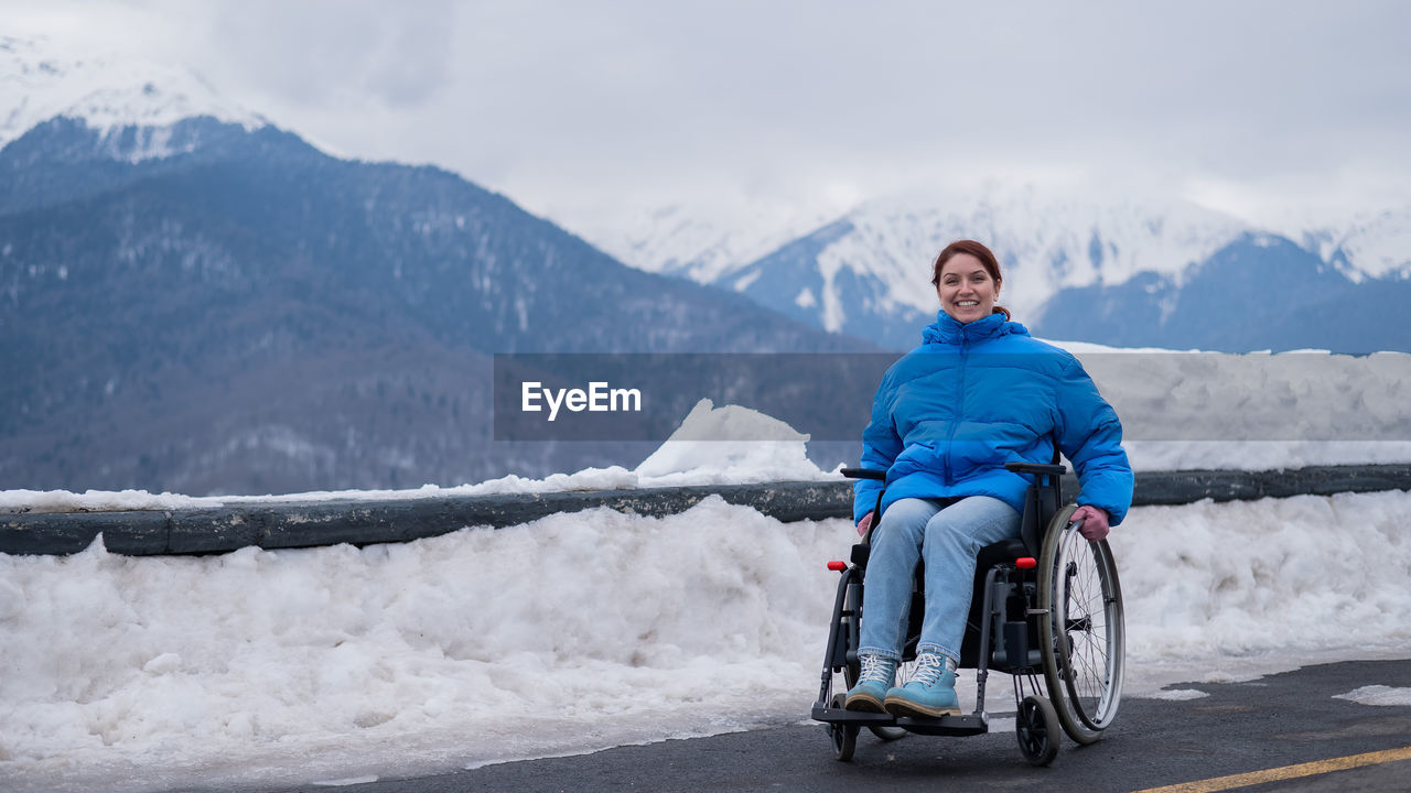 Smiling disabled woman sitting on wheelchair