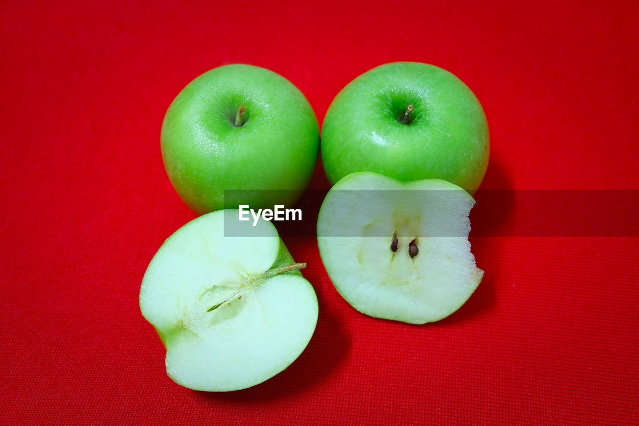 CLOSE-UP OF APPLES ON RED TABLE