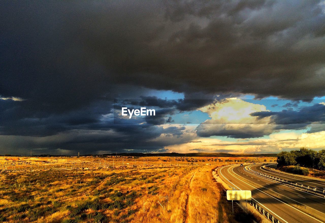 SCENIC VIEW OF DRAMATIC SKY OVER ROAD