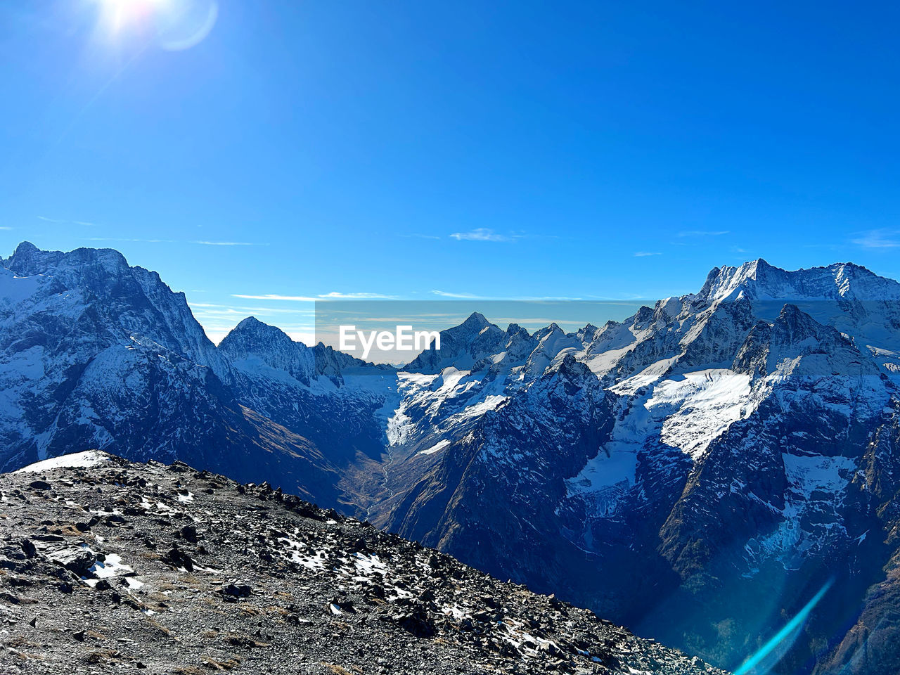 panoramic view of snowcapped mountains against blue sky