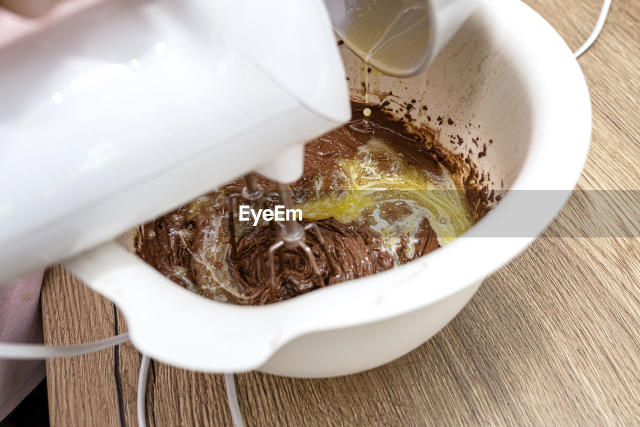 Mixing the dough with a hand mixer with a whisk with melted butter added, the dough is thick mass.