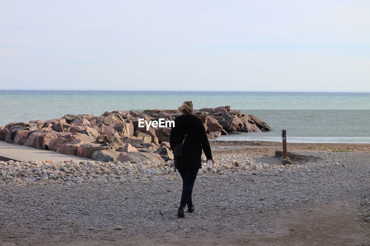 REAR VIEW OF WOMAN ON BEACH