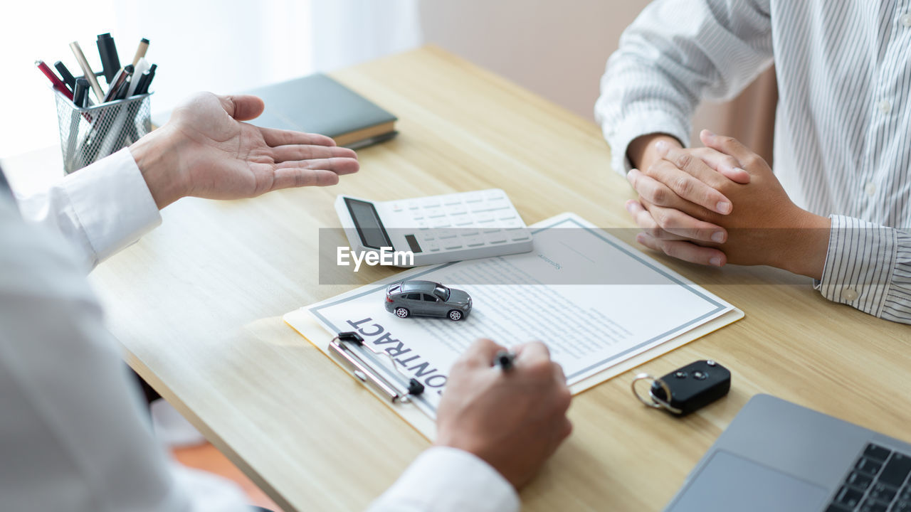 Midsection of business colleagues working at desk in office