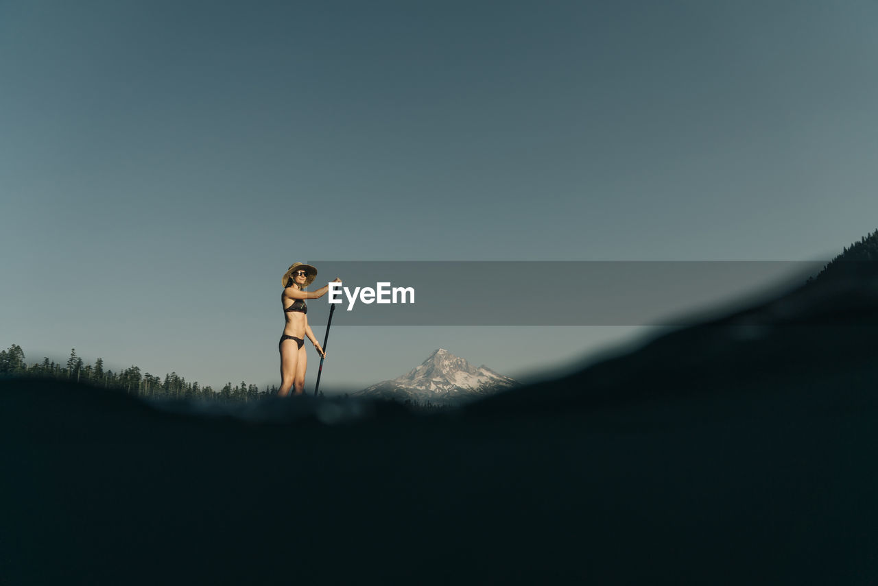 A young woman enjoys a standup paddle board on lost lake in oregon.