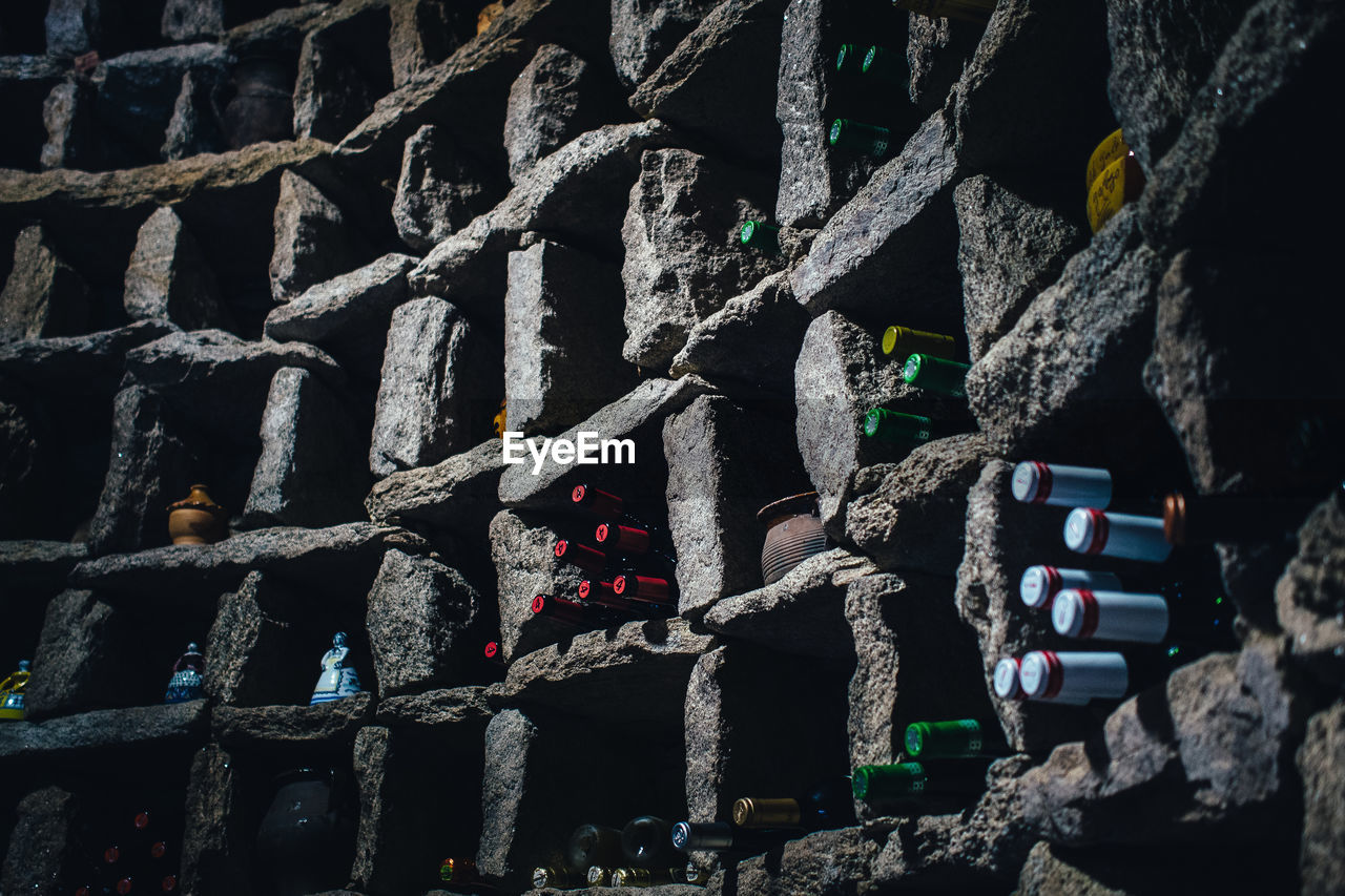 Low angle view of alcohol bottles in stone shelves