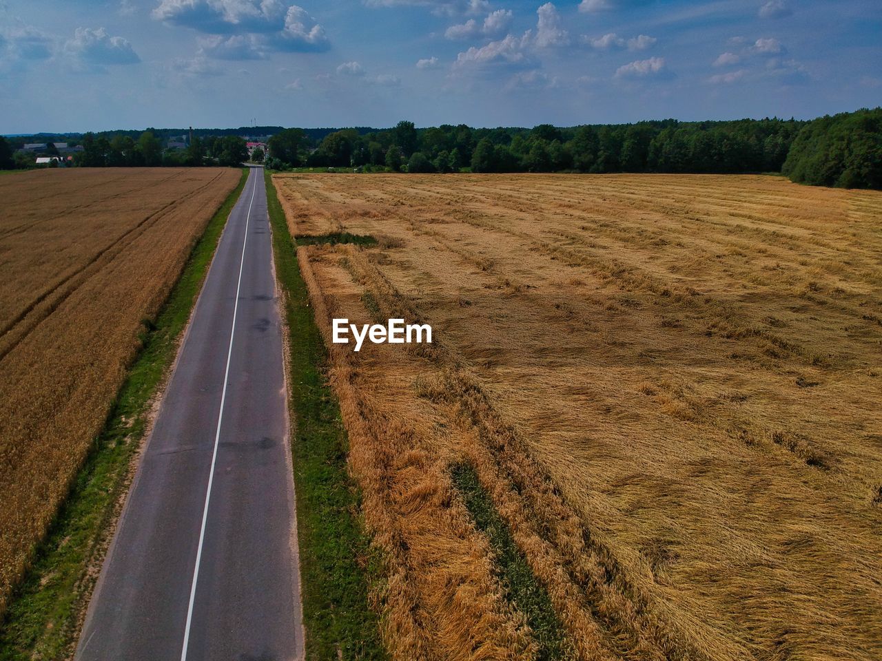 Road amidst field against sky