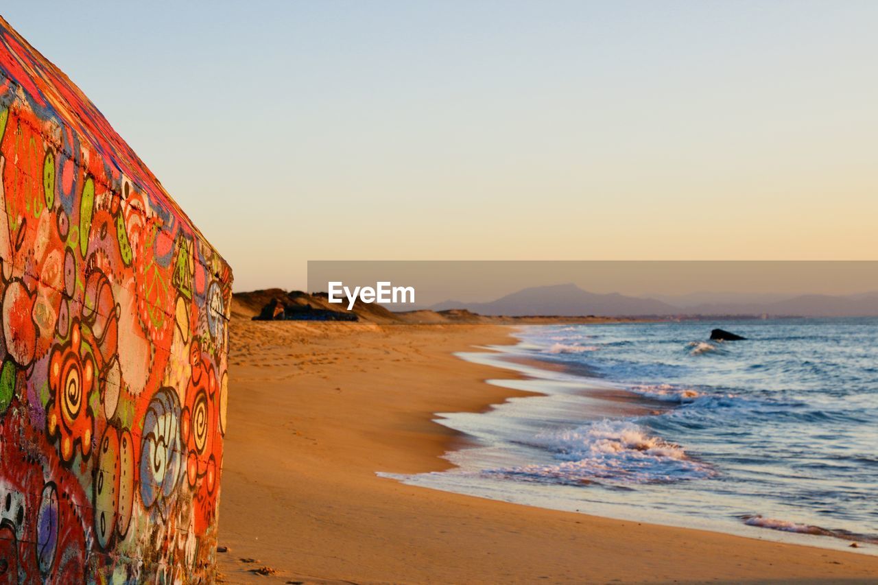 SCENIC VIEW OF SEA AGAINST CLEAR SKY AT SUNSET