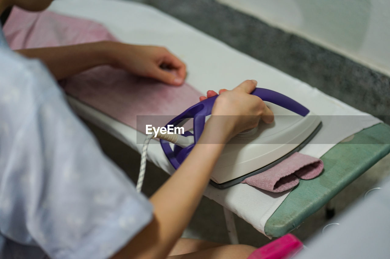 High angle view of woman ironing clothing