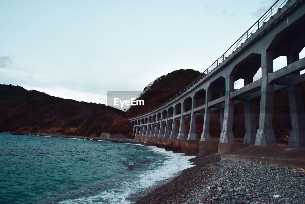 Bridge over beach against clear sky