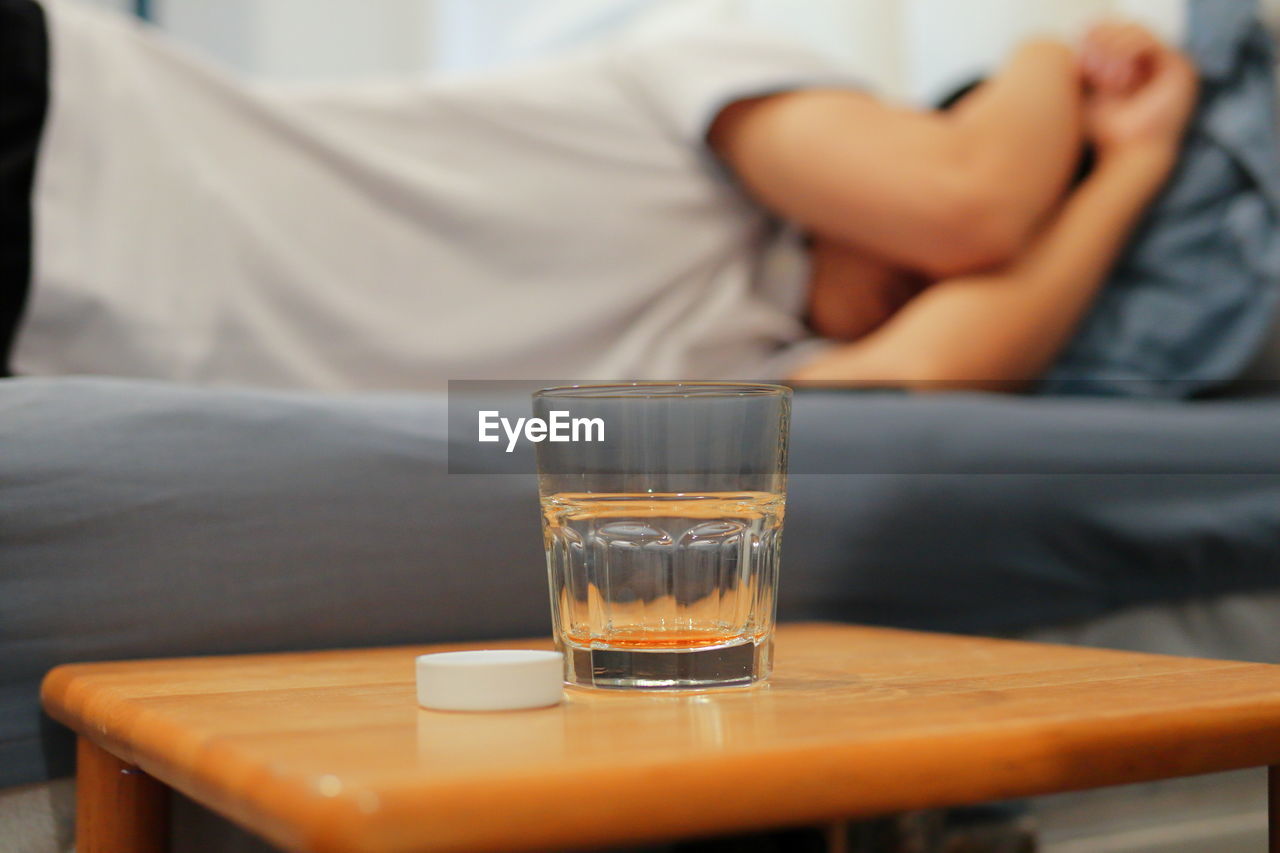 MIDSECTION OF MAN SITTING ON TABLE AT HOME