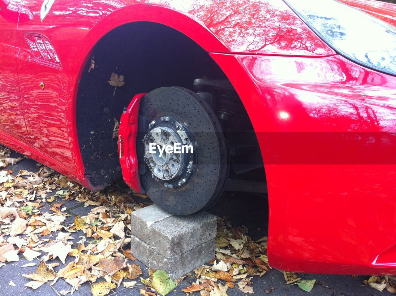 CLOSE-UP OF RED CAR ON ROAD