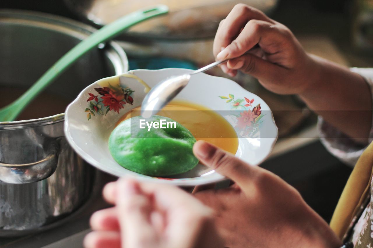 MIDSECTION OF WOMAN PREPARING FOOD IN KITCHEN