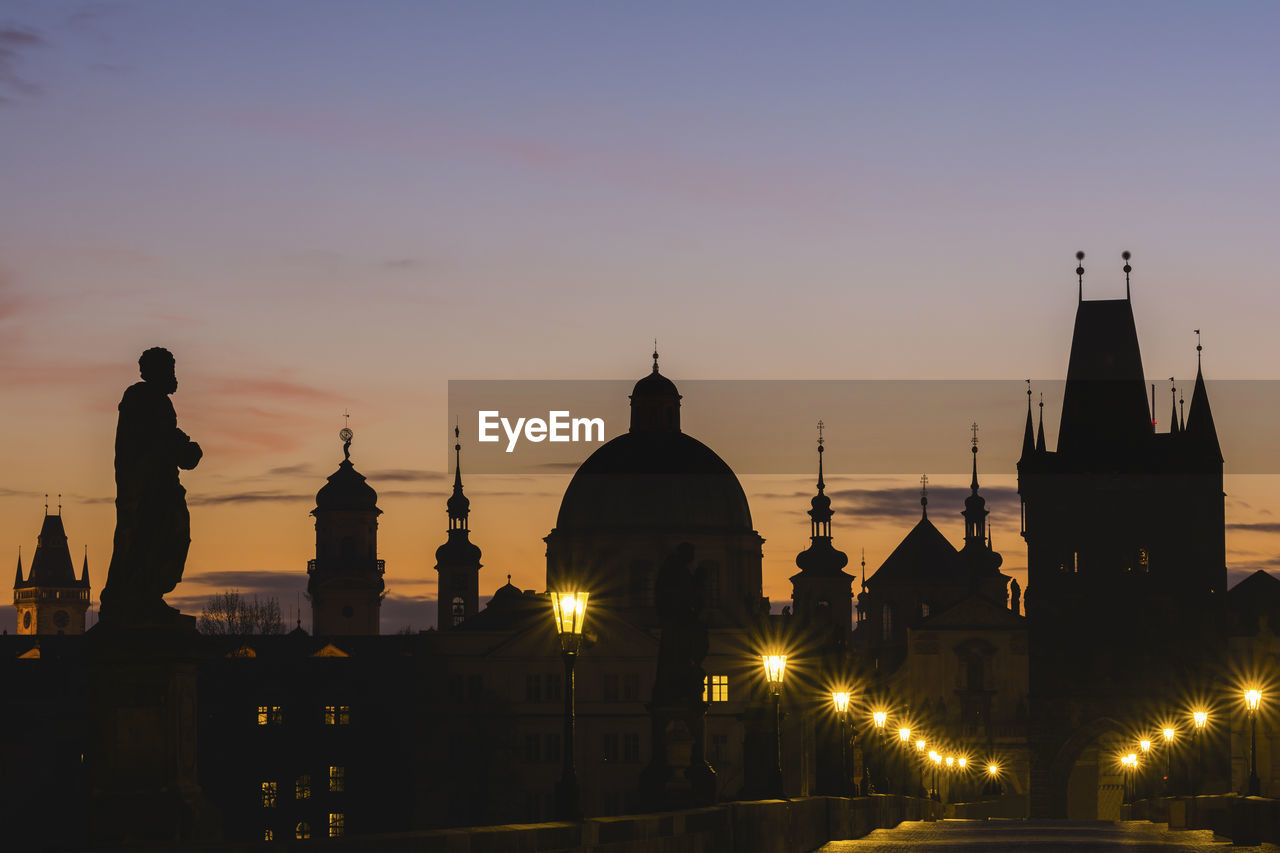 SILHOUETTE OF BUILDINGS AGAINST SKY AT SUNSET