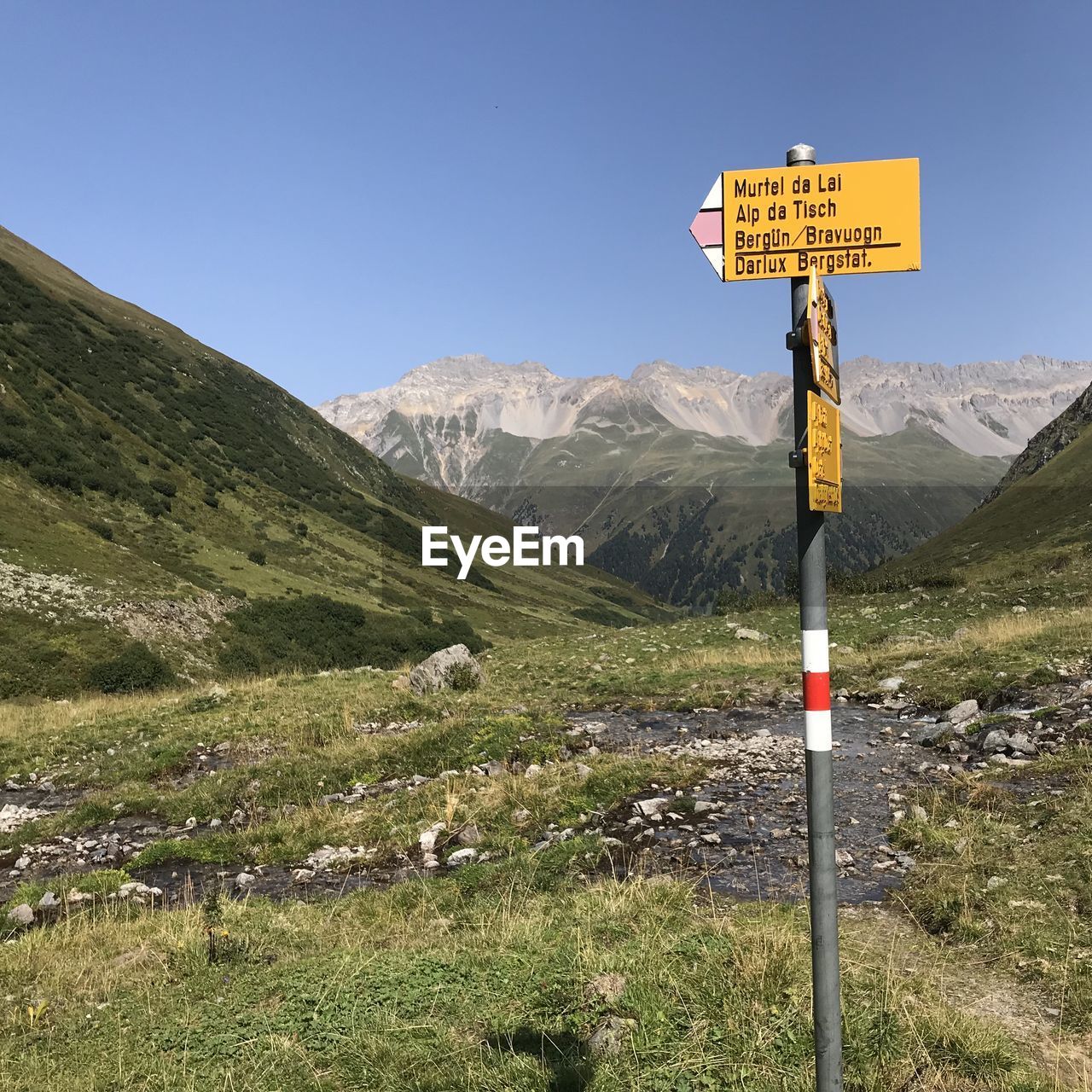 ROAD SIGN ON LANDSCAPE AGAINST SKY