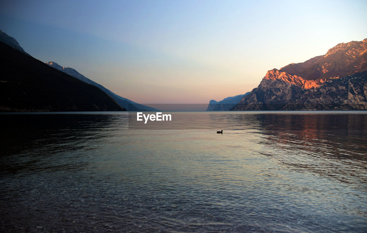 Scenic view of sea and mountains at sunset