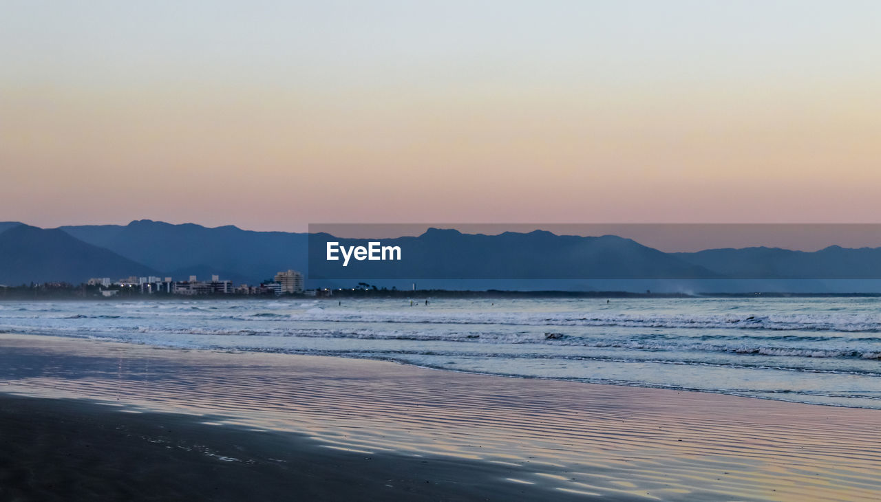 SCENIC VIEW OF BEACH AGAINST SKY DURING SUNSET